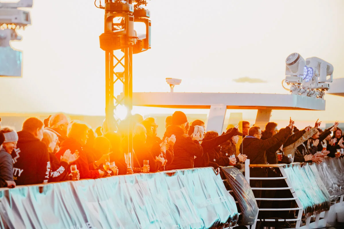 Festivalgjester på skipsdekket i solnedgang under Full Metal Cruise Part I.